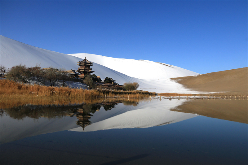 鳴沙山月牙泉景區(qū)雪景。敦煌市委宣傳部供圖，張曉亮攝